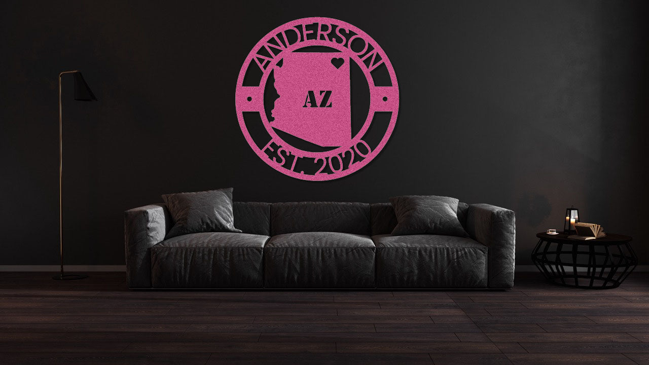 a living room with a black couch and a pink logo on the wall