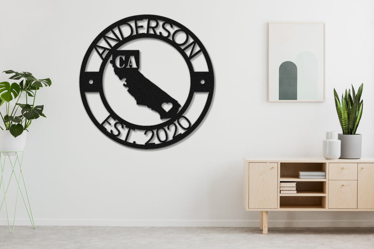 a black and white clock on a wall next to a potted plant