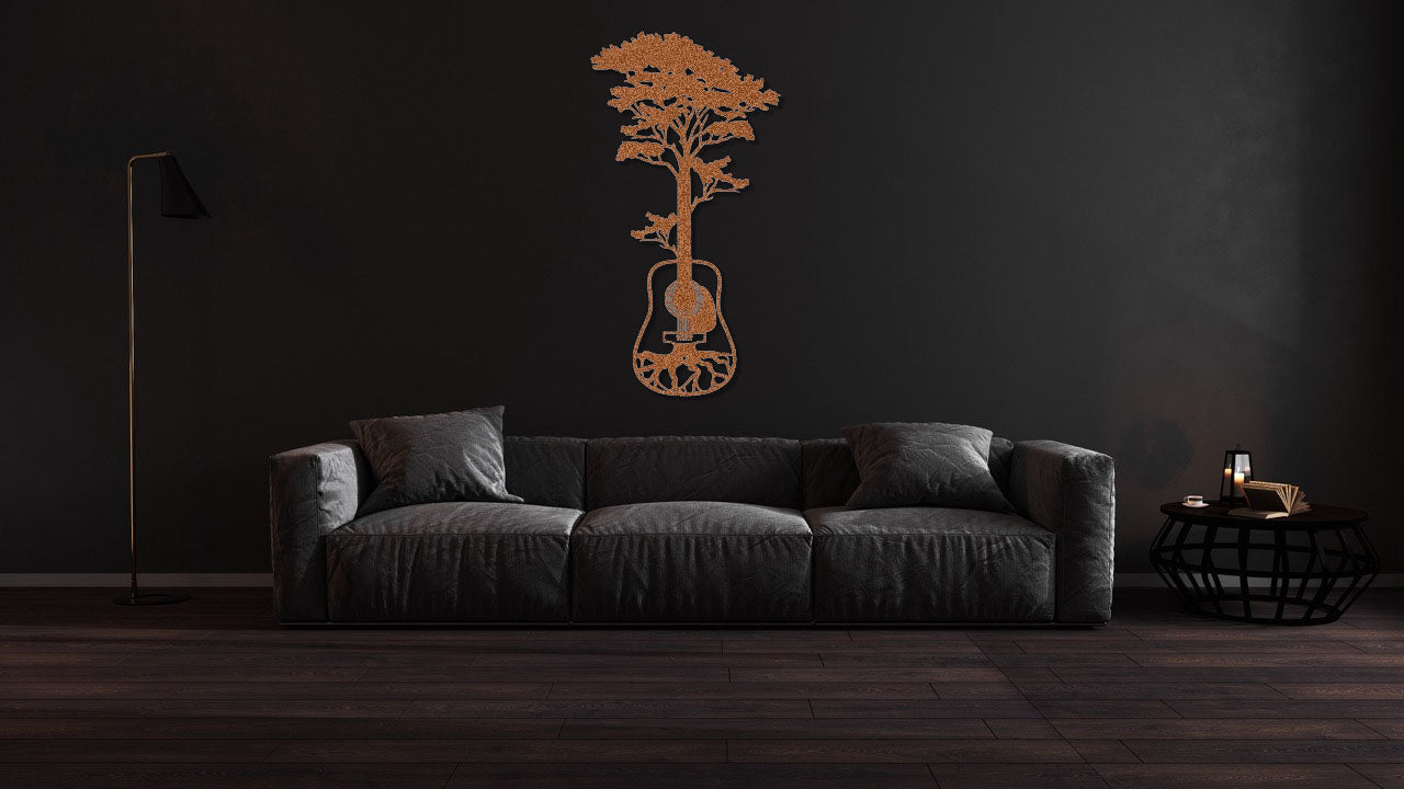 a living room with a black couch and a flower vase on the wall